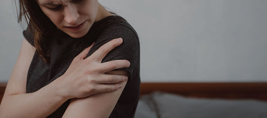 woman holding her shoulder in pain