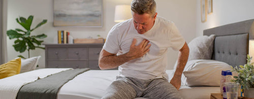 man on bed unable to sleep from reflux