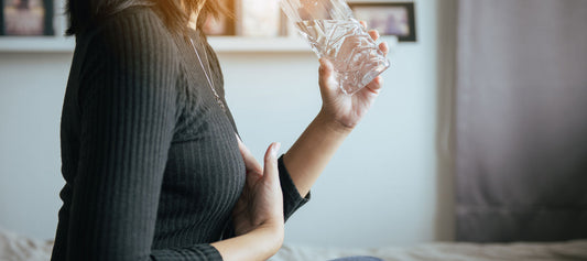 woman holding chest from acid reflux pain 