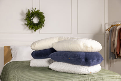 Stack of body pillows with war ivory, midnight navy and cooling case